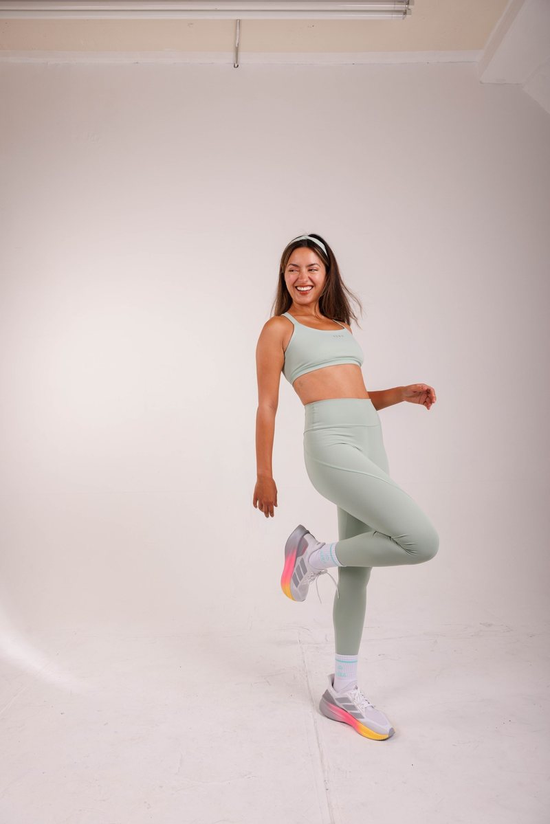 AERA community, woman stretching in a sky blue set